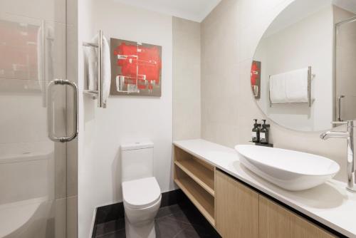 奥克兰奥克兰城市生活酒店的白色的浴室设有水槽和卫生间。