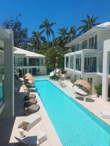 长滩岛Privates Suites in Station 1 Boracay Island的一座带躺椅的游泳池和一座建筑