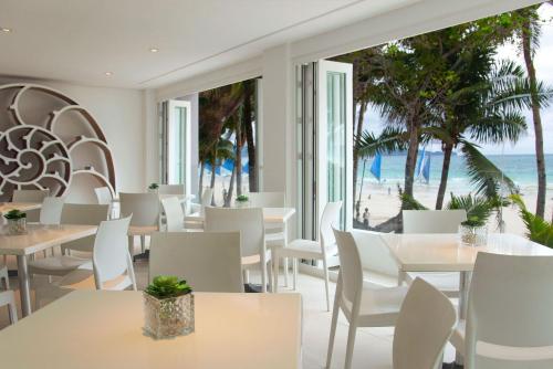 长滩岛Privates Suites in Station 1 Boracay Island的一间带桌椅的餐厅,享有海滩美景