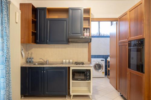 贝加莫Il Cortiletto - Apartment的厨房配有蓝色橱柜、水槽和洗碗机。