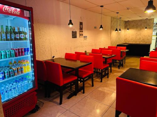 瓜鲁柳斯on park hotel e estacionamento traslado的一间设有红色椅子和苏打水机的餐厅