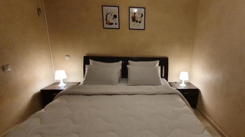 马拉喀什Cozy apartment in the heart of marrakech的一间卧室配有一张大床,上面有两盏灯