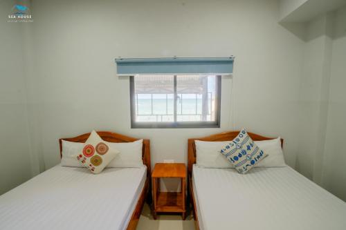 Ấp Bình HưngSea House的小型客房设有两张单人床和窗户。
