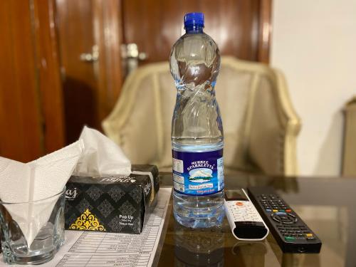 伊斯兰堡E Lodge的遥控器旁边的桌子上的一瓶水