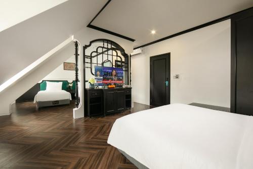 下龙湾Elegant Boutique Hotel Ha Long的卧室配有白色的床和电视
