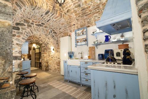 梅斯塔Byzantine Home in the Castle的厨房配有蓝色橱柜和砖墙