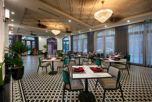 下龙湾Elegant Boutique Hotel Ha Long的用餐室配有桌椅和吊灯。