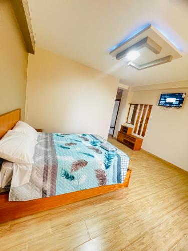 里奥班巴Hostal Paraíso de Los Andes的一间卧室配有一张床和一台平面电视