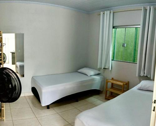 戈亚斯州上帕莱索Recanto da Chapada的一间卧室设有两张床和窗户。