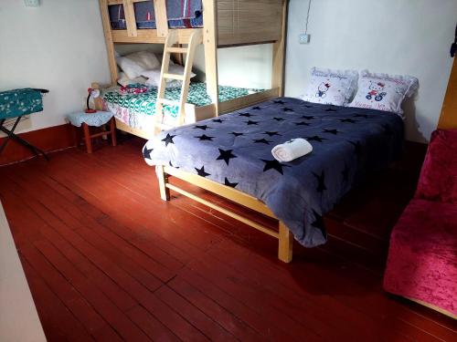 塔尔马Casa de Campo-Hospedaje Munay Wasi的一间卧室配有一张床和一张双层床。