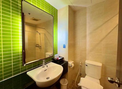 彭世洛Wangchan Riverview的浴室设有水槽、卫生间和绿色瓷砖。
