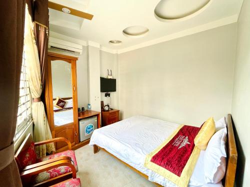 同文Thái Thịnh Hotel的一间卧室配有一张床、一台电视和一把椅子