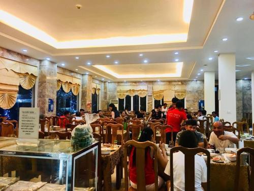 清化Sao Biển Hotel Hải Tiến的一群坐在餐厅桌子上的人