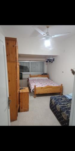 Qaryat Shurūqشاليه العائلة的一间卧室设有两张床和窗户。