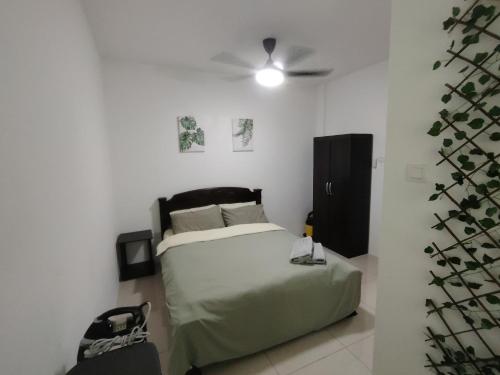 米里JNJ Miri Homestay - Miri Serene Shangrila, Luak with 4-bedroom的一间卧室配有一张床和吊扇