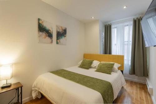 纽约Stylish 5 Bedroom Apt in NYC!的一间卧室配有一张带绿色枕头的大床