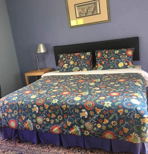 清迈Giardino Di San Sai的床上配有色彩缤纷的被子和枕头