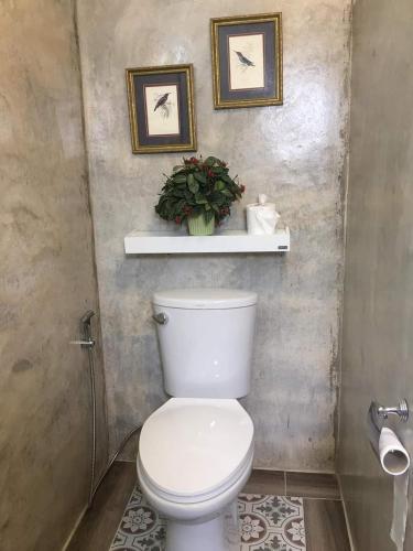 清迈Giardino Di San Sai的浴室设有卫生间,墙上挂有两张照片