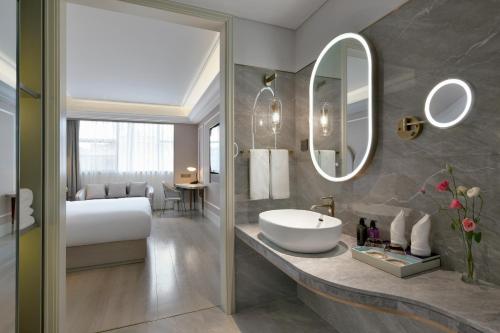深圳深圳南山深圳湾美居酒店的浴室设有床、水槽和镜子