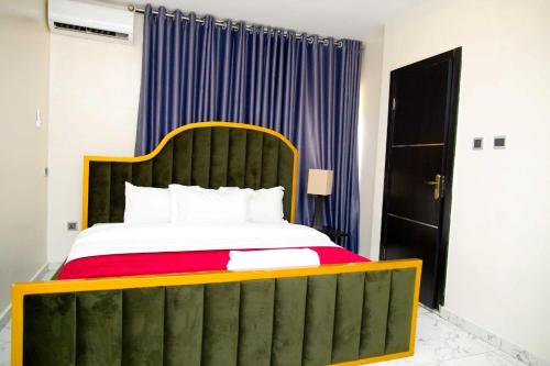 拉各斯U2 One Bedroom Apartment的一间卧室配有一张大床和绿色床头板
