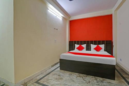 德里OYO Flagship Hotel Elite Inn的一间卧室配有一张红色墙壁的床