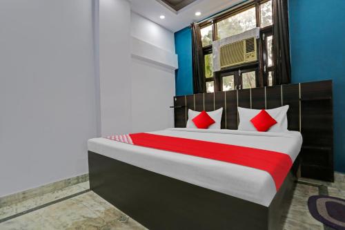 德里OYO Flagship Hotel Elite Inn的一间卧室配有一张带红色枕头的大床