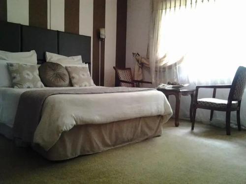 卢萨卡Leopards road room的一间卧室配有一张大床和一张桌子及椅子