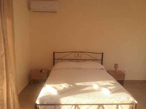 佩塔里德海昂Nereids Apartments-Galene的一间卧室配有一张带白色床单的床和一扇窗户。