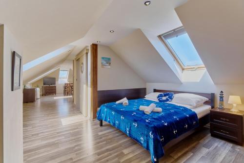 格里兹鲍Villa Konwalia的一间卧室配有一张带蓝色床单的床和一扇窗户。