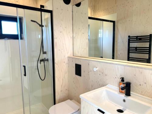 韦斯特卡佩勒Hello Zeeland - Tiny House Zeeuwse Liefde 5的带淋浴、盥洗盆和镜子的浴室