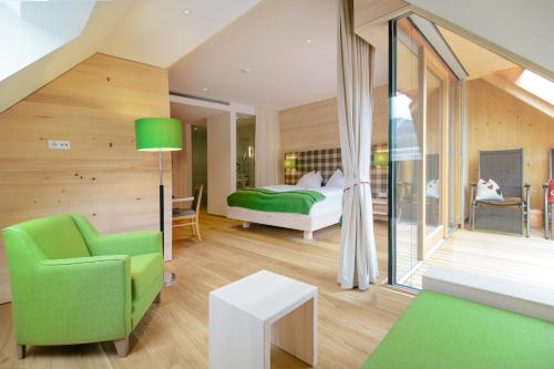圣吉尔根Hotel Gasthof zur Post的一间卧室配有一张床和一把绿色椅子