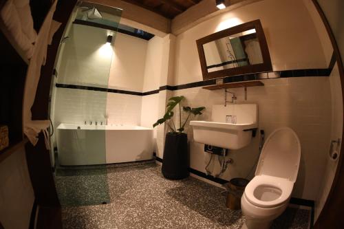 Bang ChakBaanrongmai Canal Front Cafe & Homestay的浴室配有盥洗盆、卫生间和浴缸。