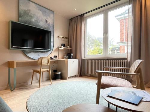 基尔基尔考夫曼罗曼蒂克酒店的客厅设有壁挂式平面电视。