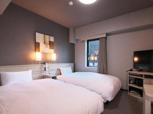 富山富山站前路线酒店的酒店客房设有两张床和电视。