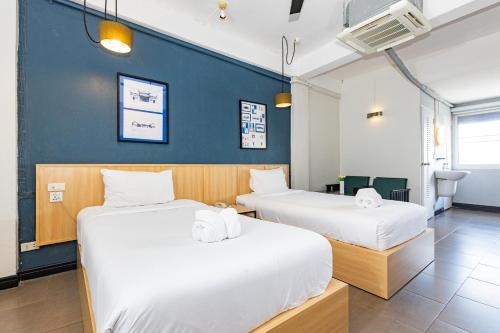曼谷Riverview Residence的蓝色墙壁客房的两张床