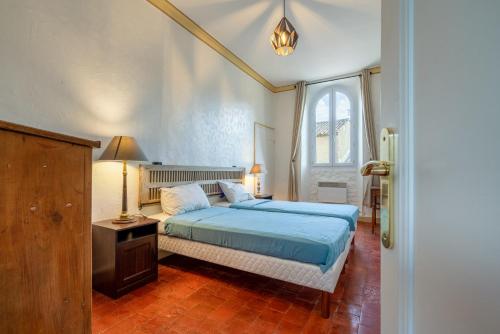 MaubecMas Côté Cour的一间卧室设有蓝色的床和窗户。