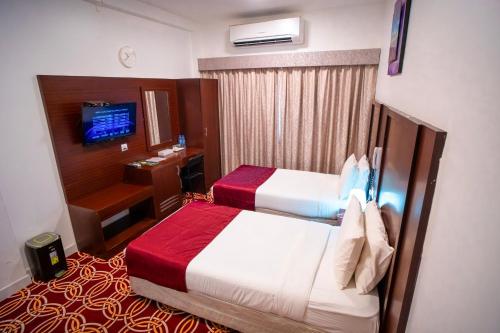 迪拜AL KARNAK HOTEL - BRANCH的酒店客房设有两张床和电视。