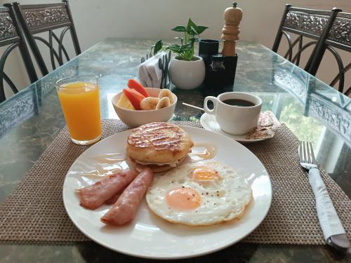 巴拿马城HOTEL BLUE COSTA Panama的包括香肠、百吉饼和橙汁的早餐食品