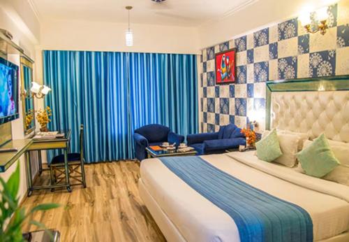 齐拉克普尔Hotel Dreamland Inn的一间卧室配有一张大床和蓝色窗帘