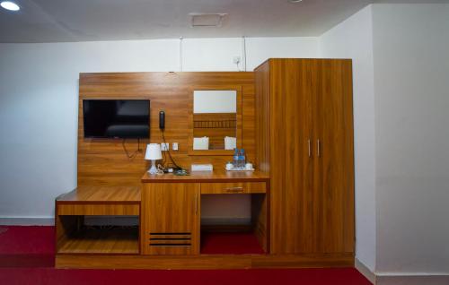 迪拜AL KARNAK HOTEL - BRANCH的客房设有书桌、电视和橱柜。