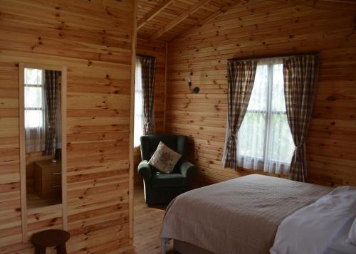 阿瓦阿格瓦喜马拉雅汽车旅馆的小屋内一间卧室配有一张床和一把椅子