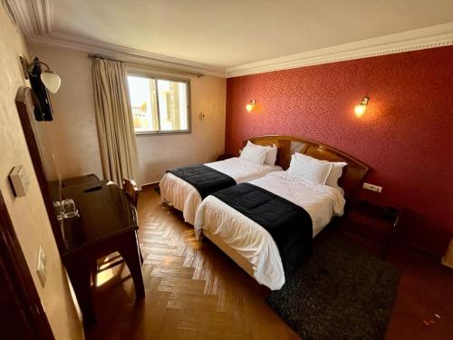 梅克内斯马耳他酒店的卧室配有一张红色墙壁上的大床