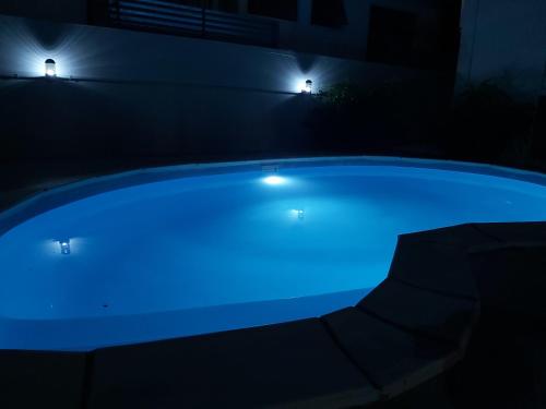 卡特勒博尔纳Yuti Homestay的游泳池在晚上点亮,灯光蓝色