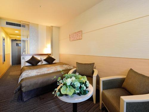 京都京都平安之森饭店的配有床和鲜花桌的酒店客房