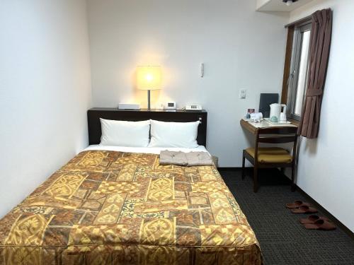 札幌Hotel Tokeidai的配有一张床、一张桌子和一张桌子的酒店客房