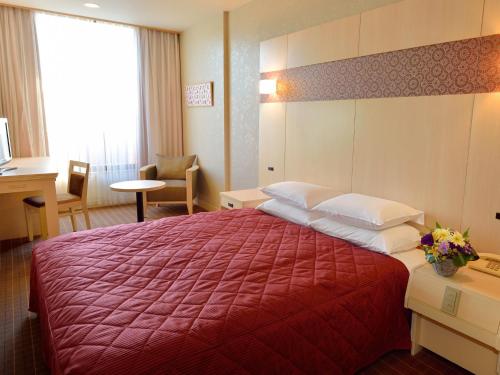 京都京都平安之森饭店的酒店客房设有一张带红色毯子的大床