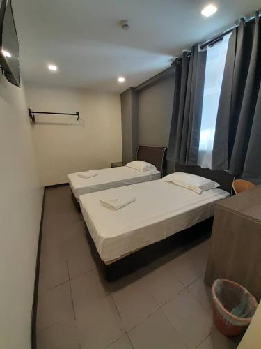 Kampung Patau Patau DuaSogo Hotel l的带窗户的客房内的两张床