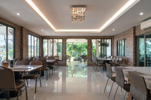 莱卡邦金家素万那普机场酒店的一间带桌椅和吊灯的餐厅