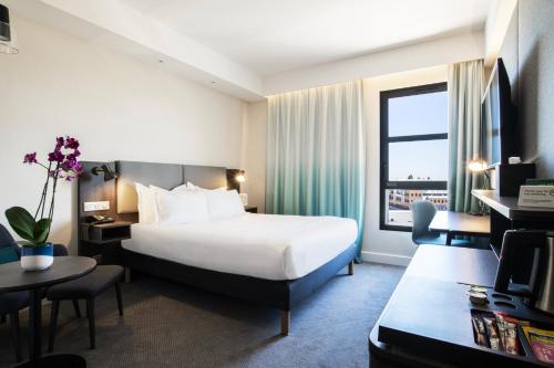 第戎Holiday Inn Dijon Sud - Longvic, an IHG Hotel的配有一张床和一张书桌的酒店客房