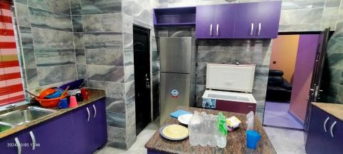 乌约THE MARBLE ARCH的一个带紫色橱柜和柜台的小厨房